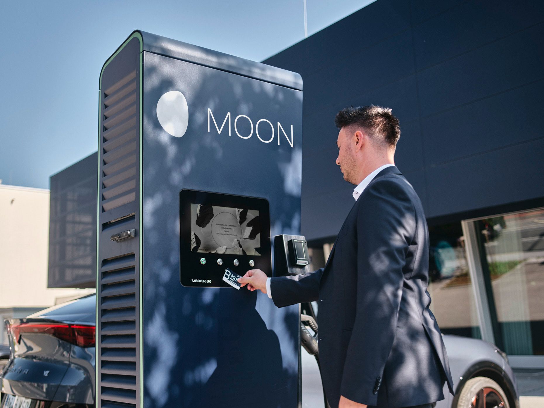 Mann hält Karte an eine Ladestation