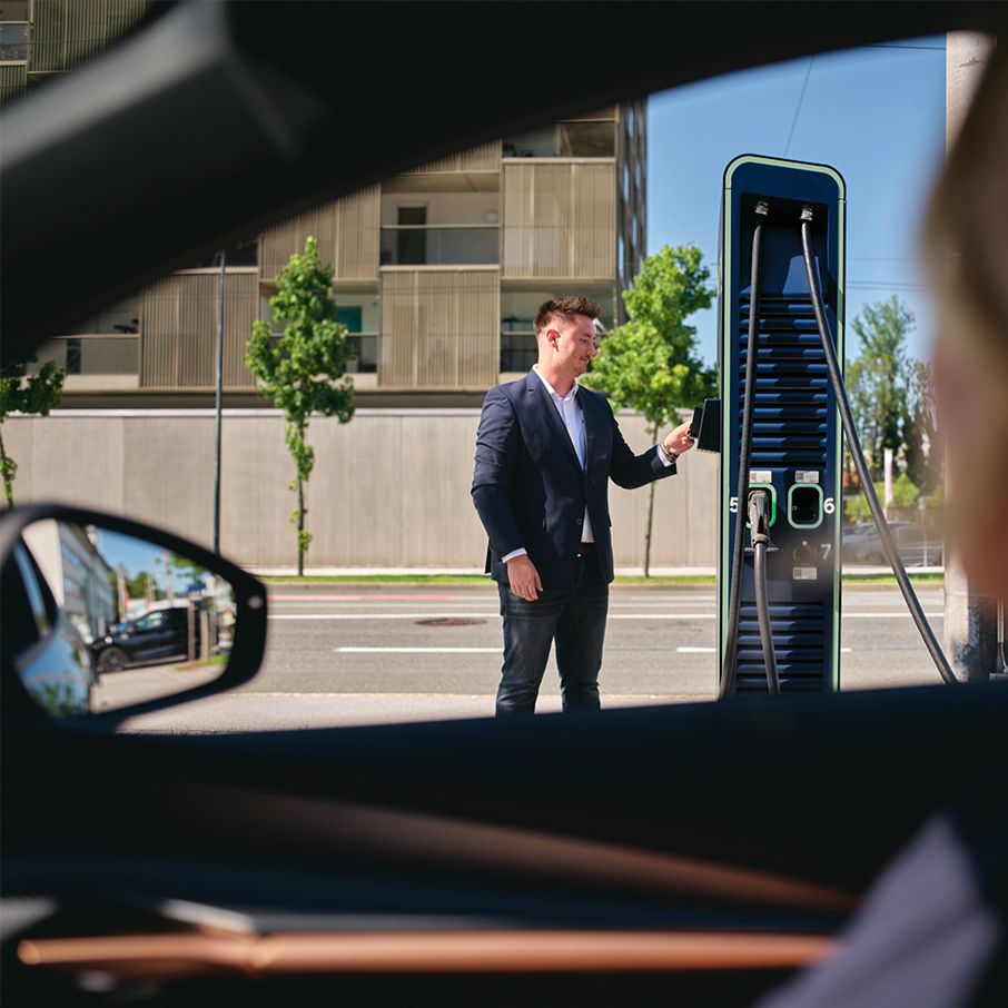 A pessoa paga com cartão em uma estação de carregamento