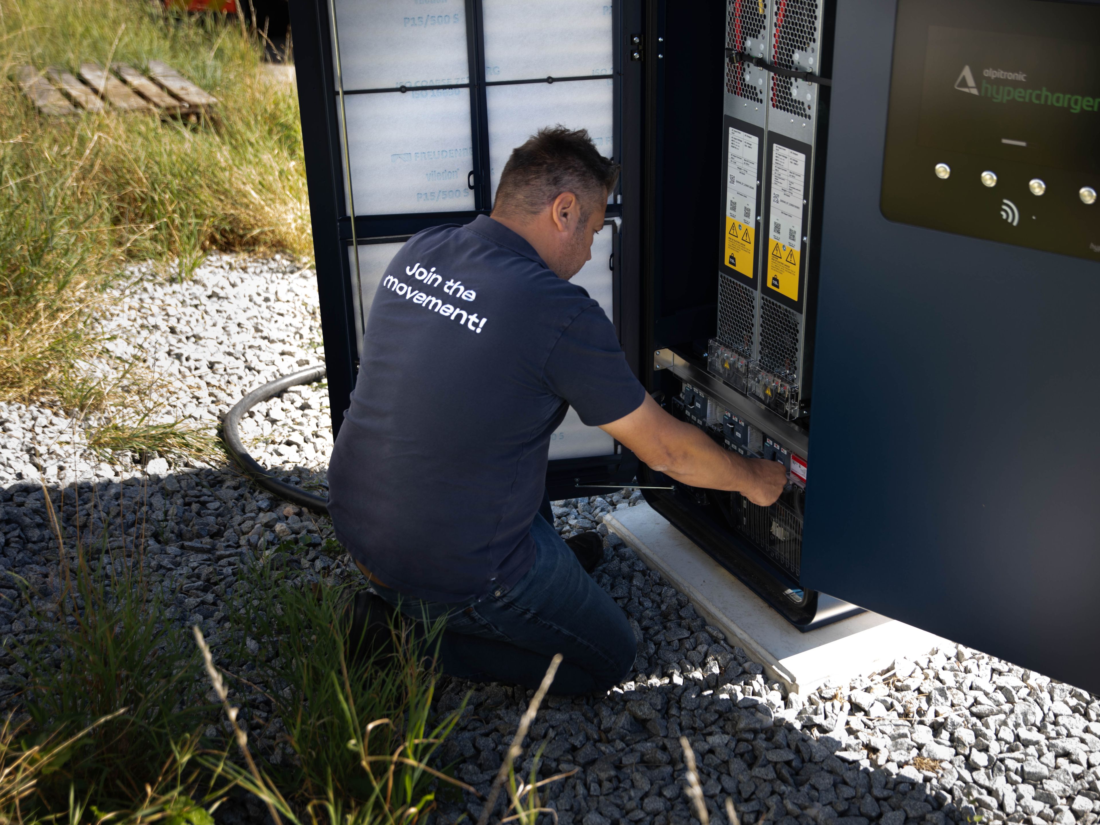 a man working on the inner workings of a HYC 200-400 fast charging station
