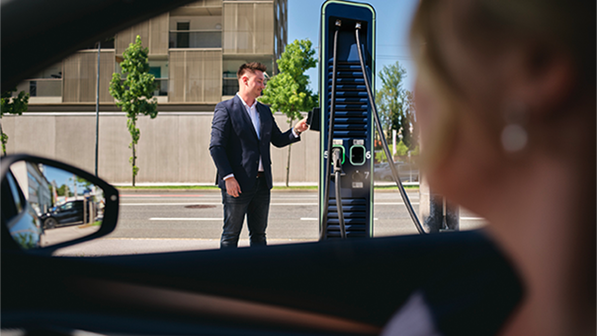 Man holds card to a charging station