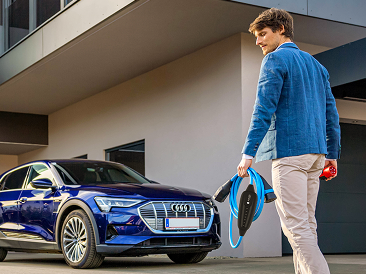 Pessoa caminha em direção a um carro com cabo na mão