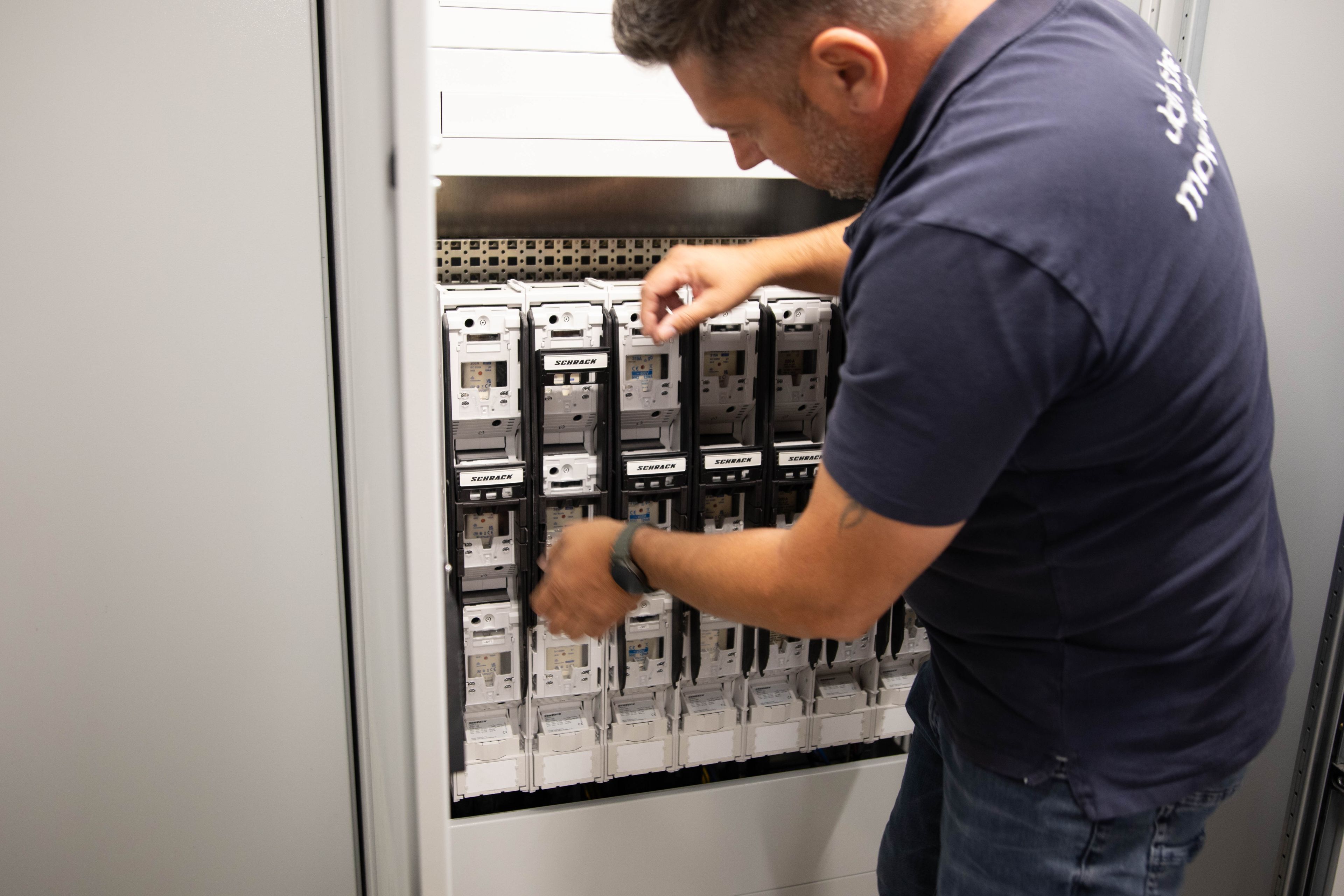 a man working on the inner workings of a HYC 200-400 fast charging station