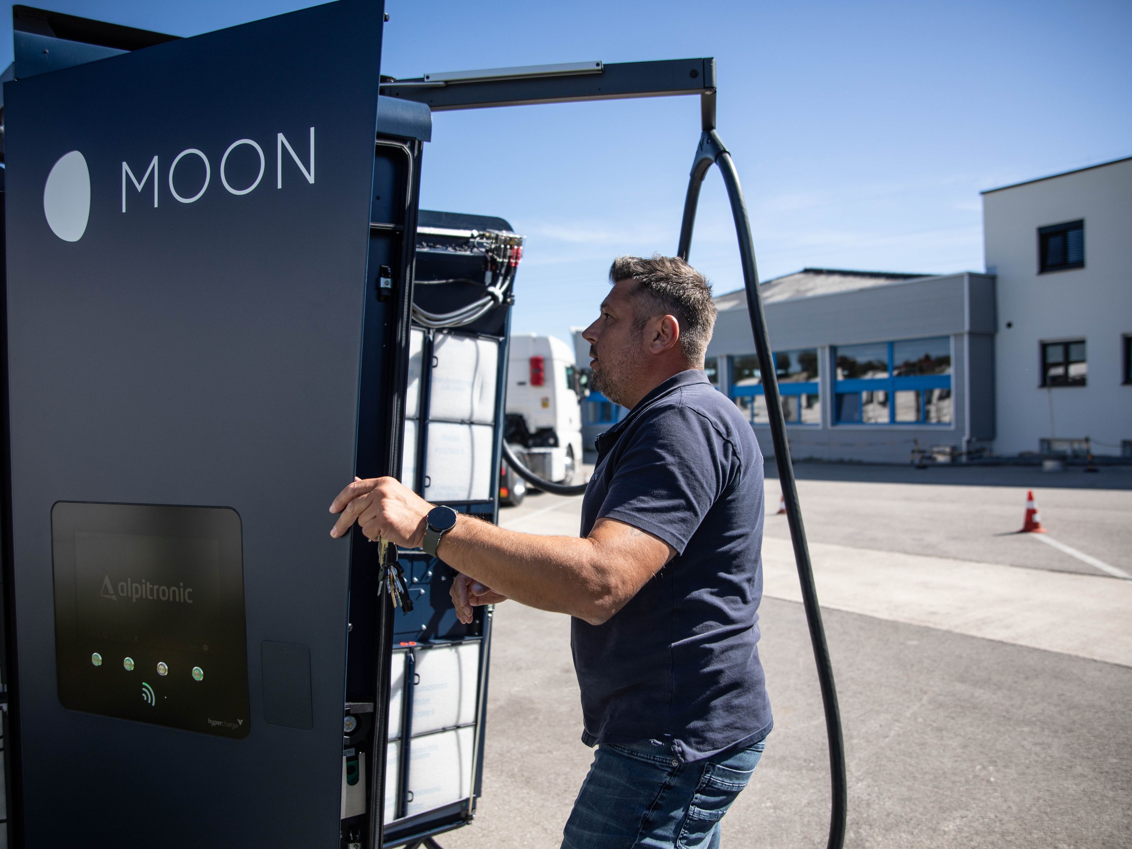 Um homem está em frente a uma estação aberta de recarga rápida HYC 200-400