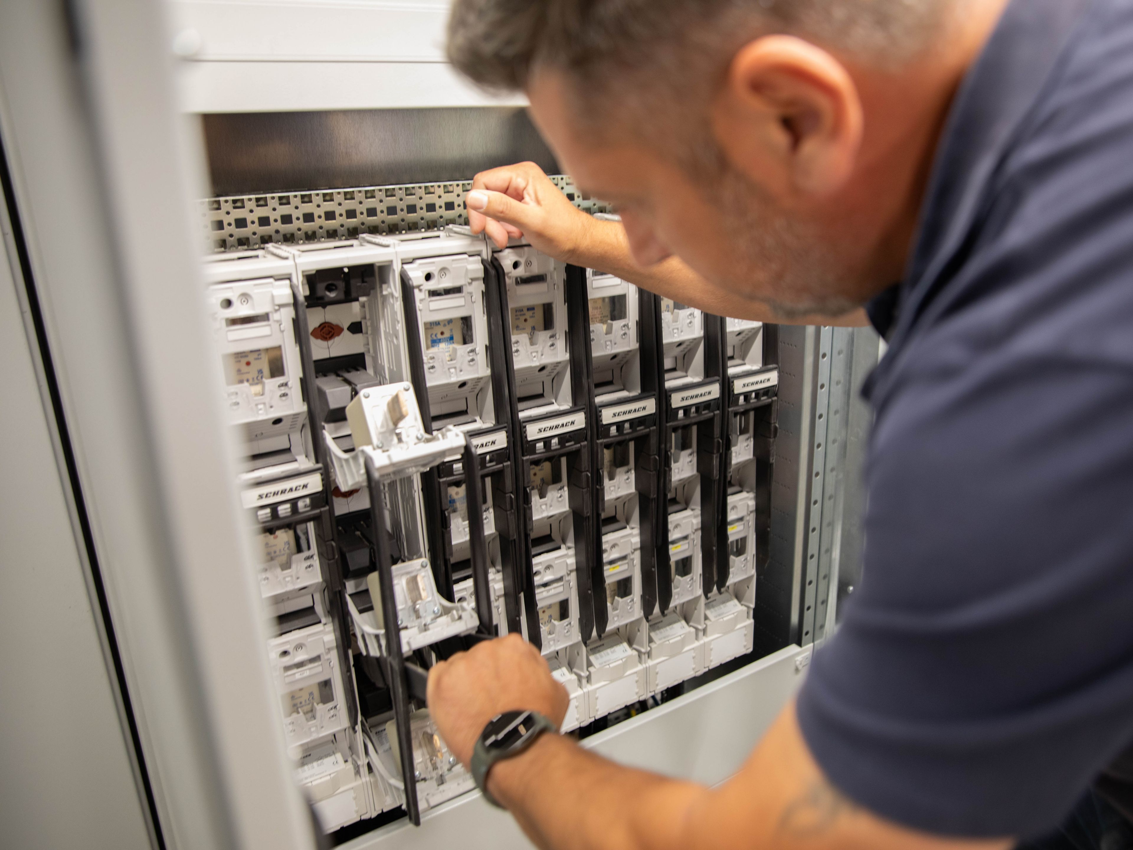 a man working on the inner workings of a HYC 200-400 fast charging station