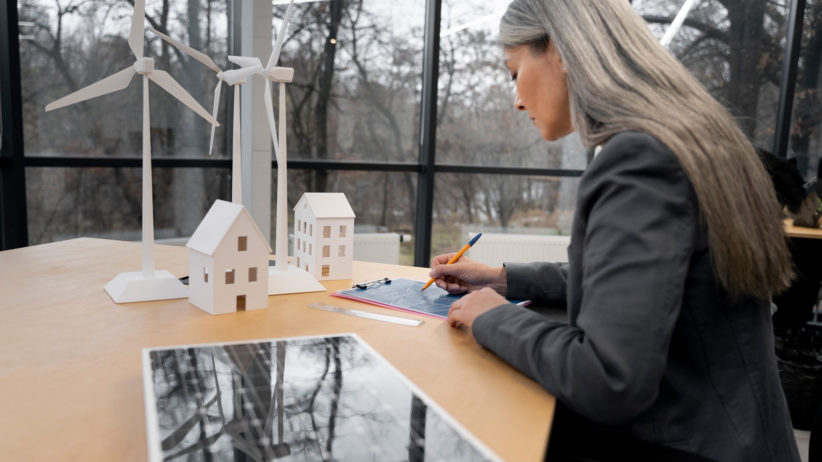 Woman stands at a table and writes something down