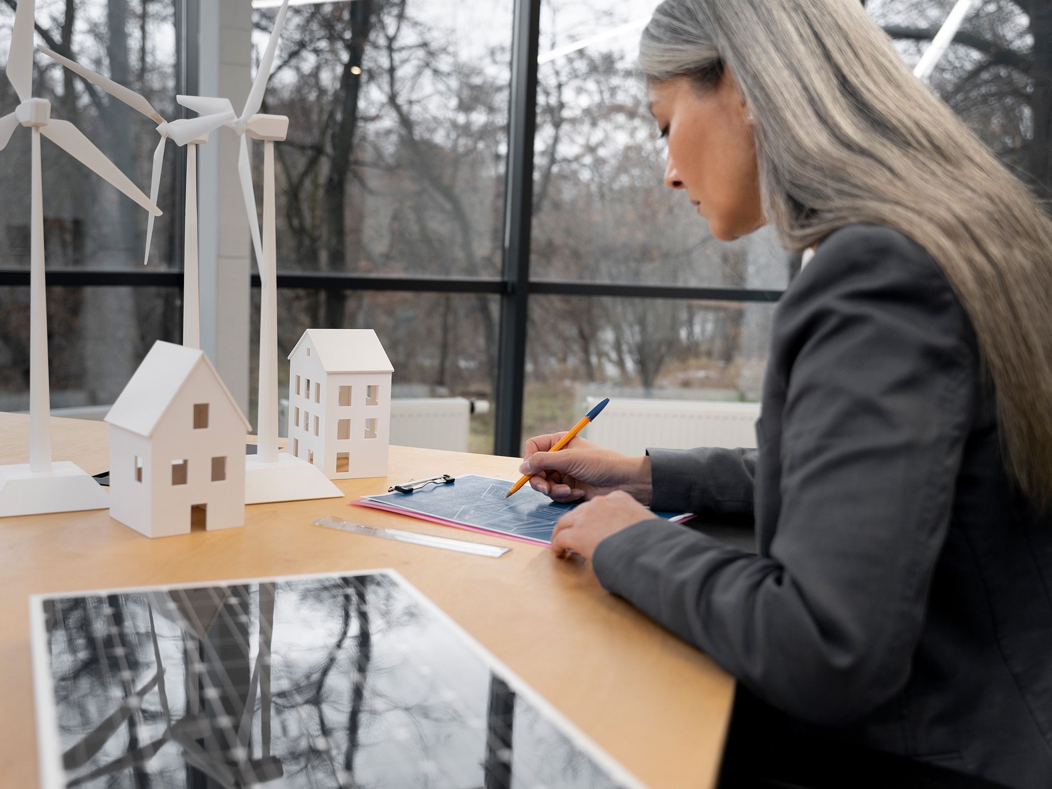 Woman stands at a table and writes something down