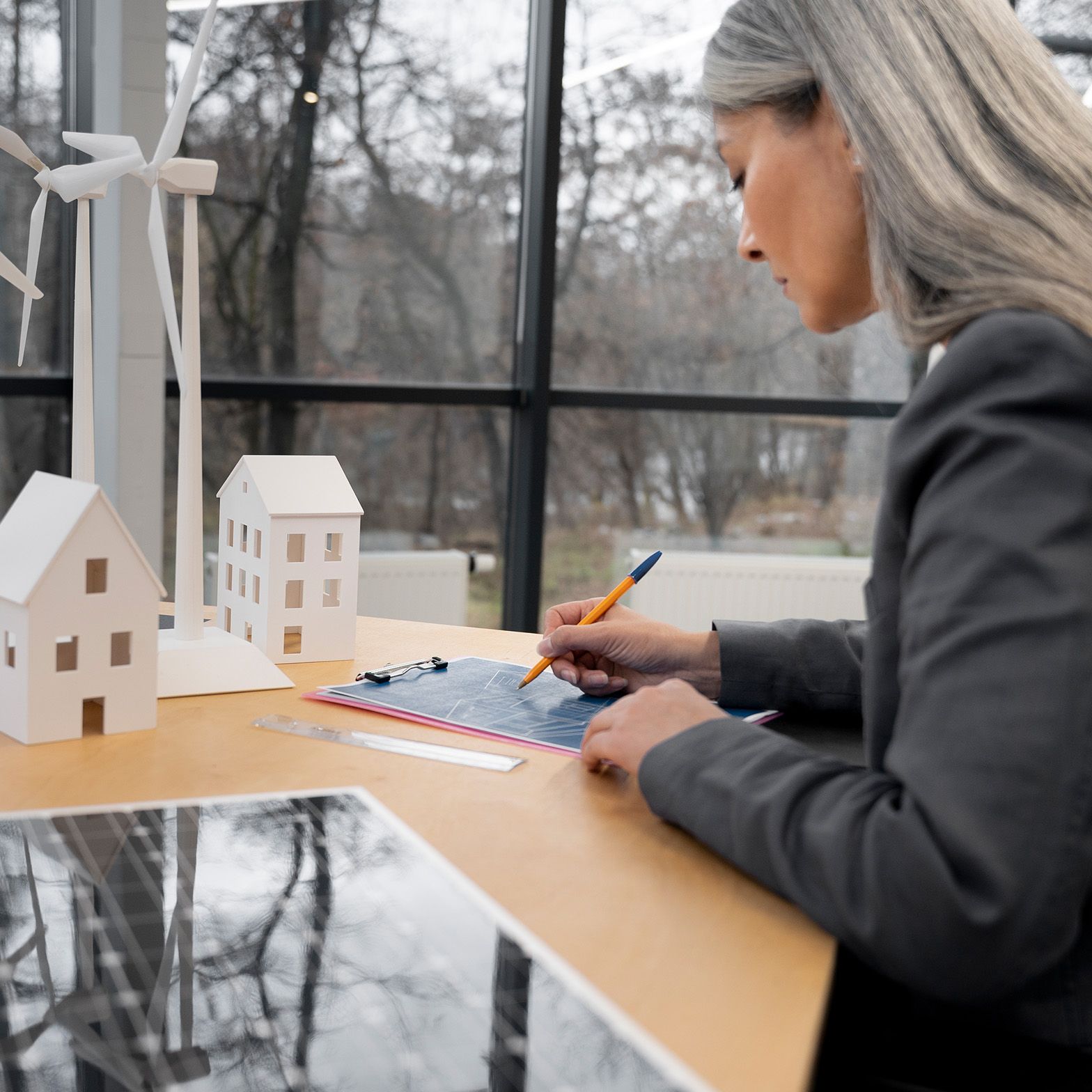 Woman stands at a table and writes something down