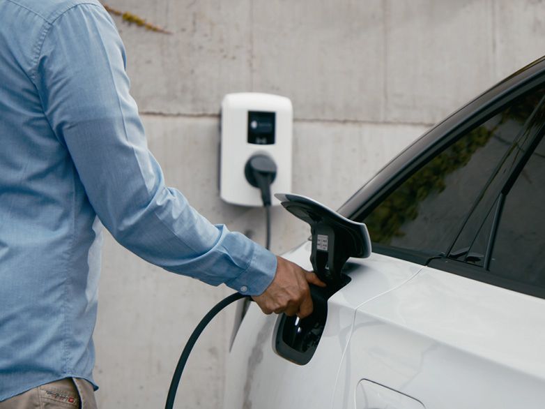 Person charging car at a wallbox
