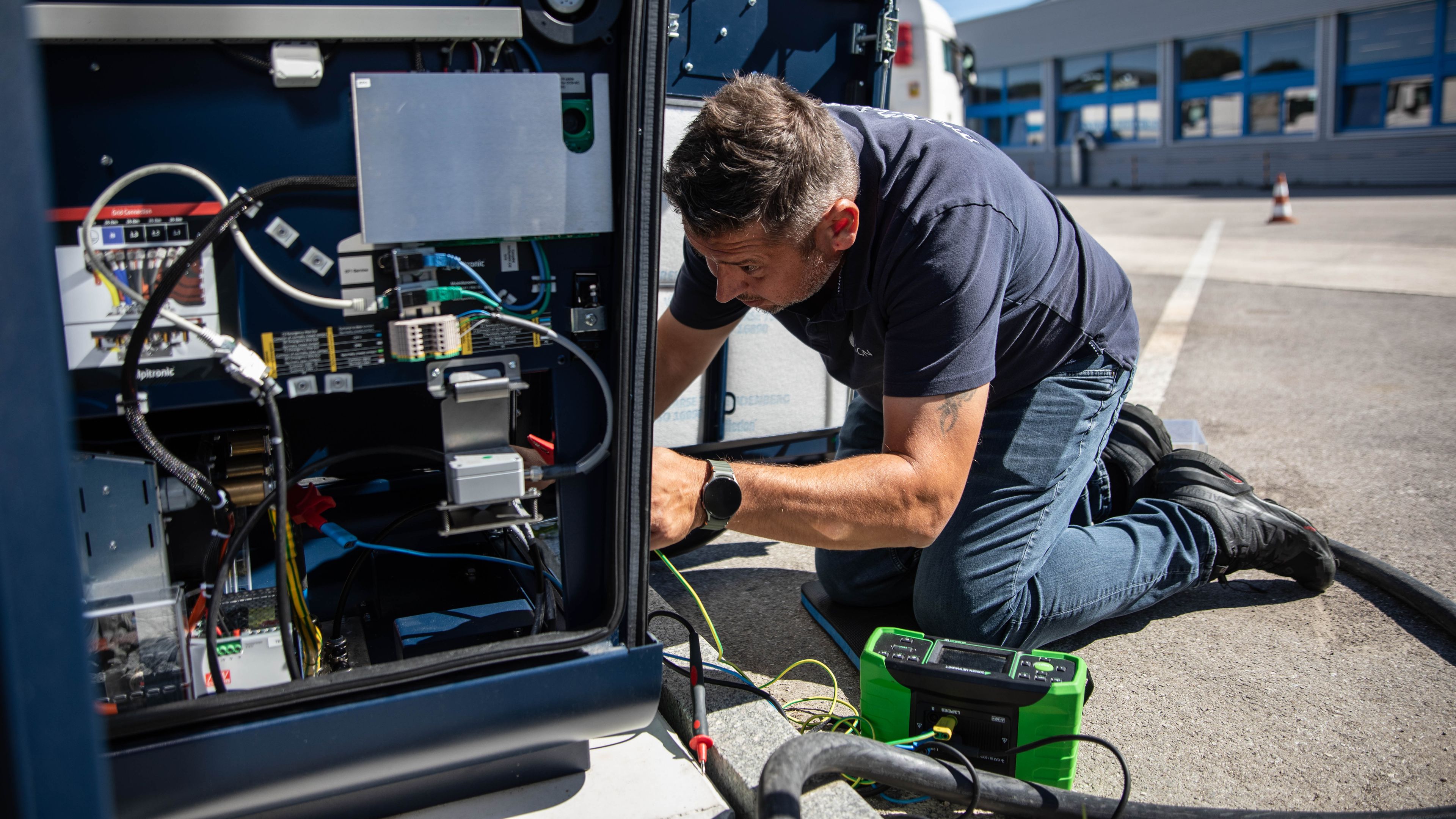 a man working on the inner workings of a HYC 200-400 fast charging station