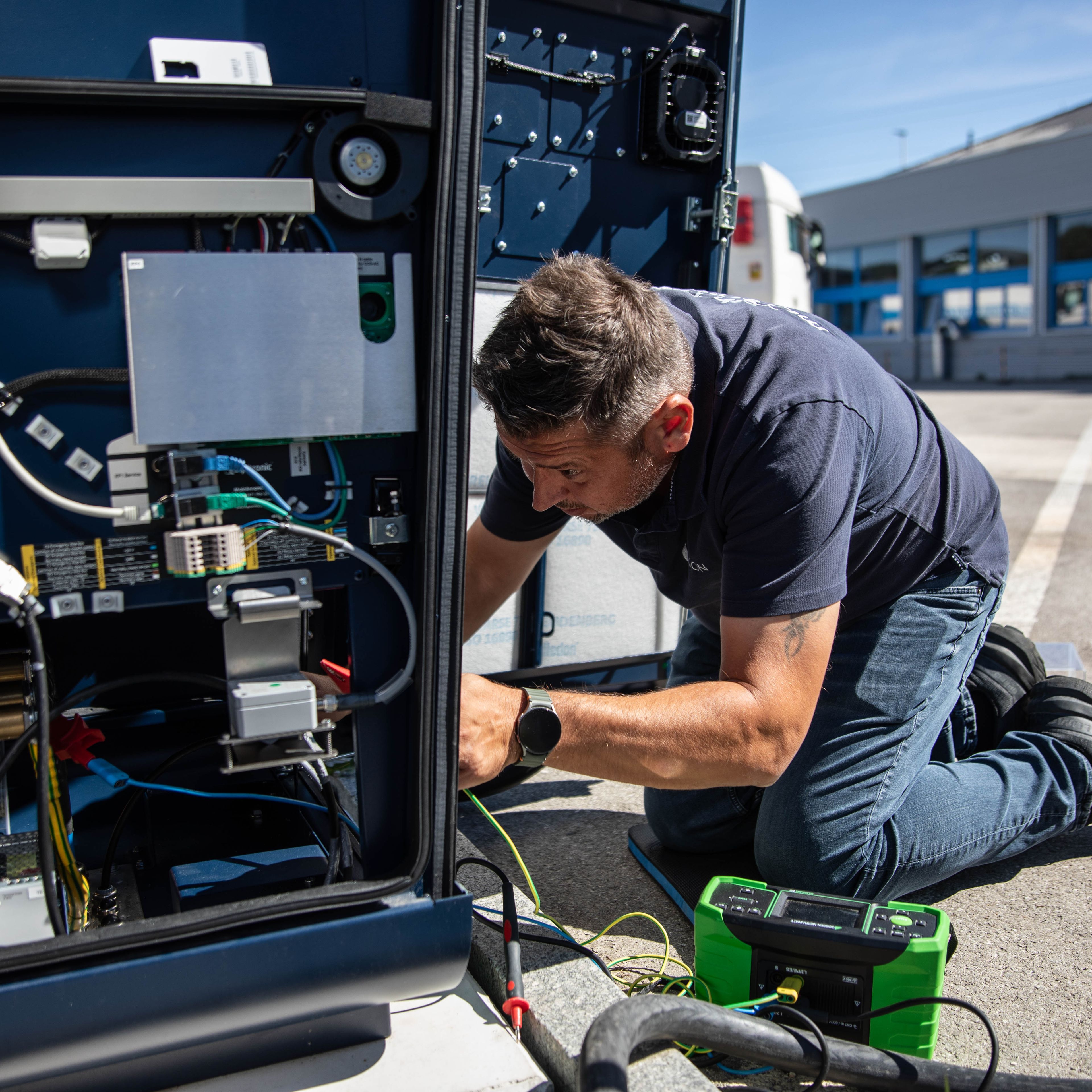 a man working on the inner workings of a HYC 200-400 fast charging station