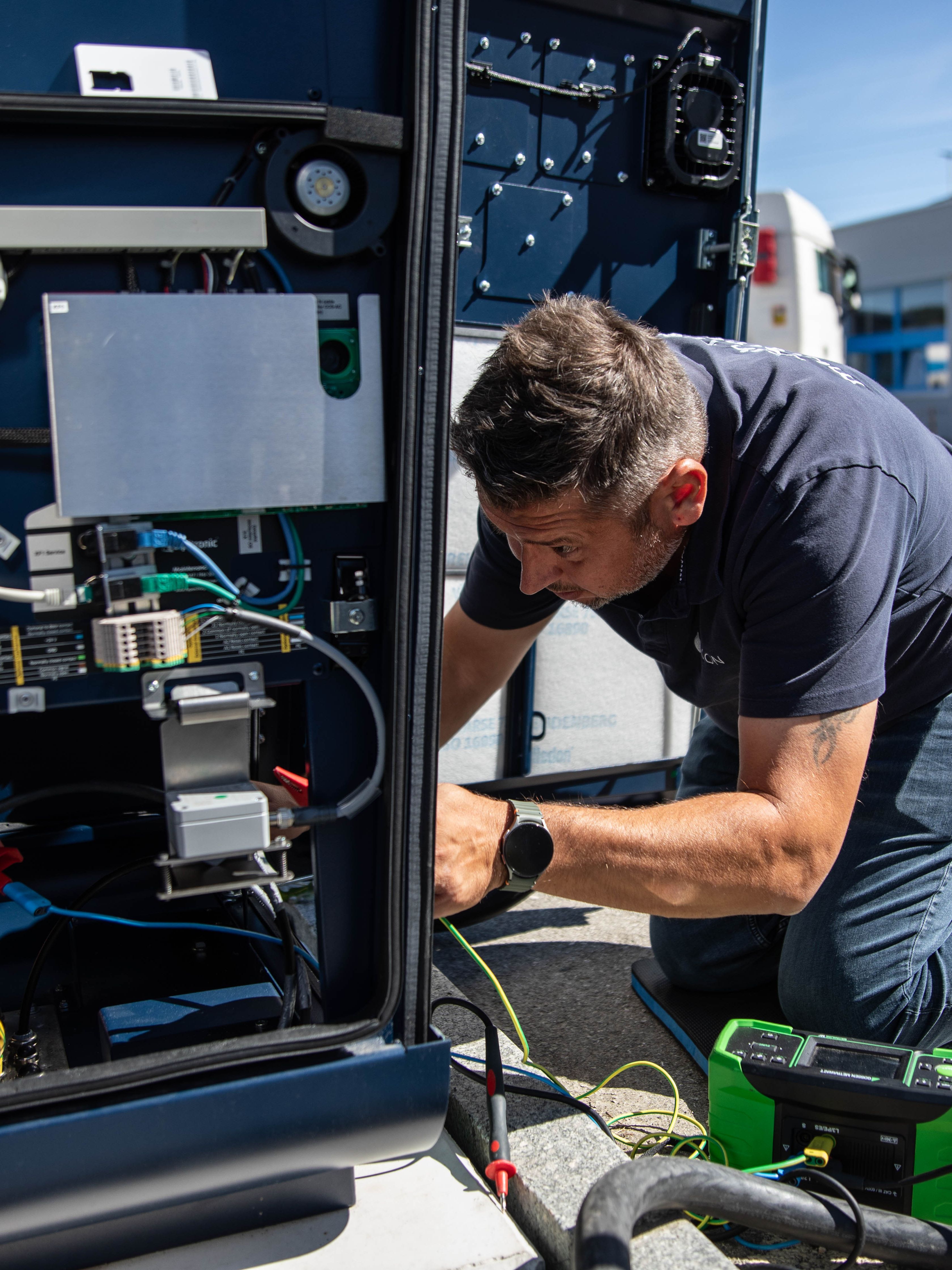 a man working on the inner workings of a HYC 200-400 fast charging station